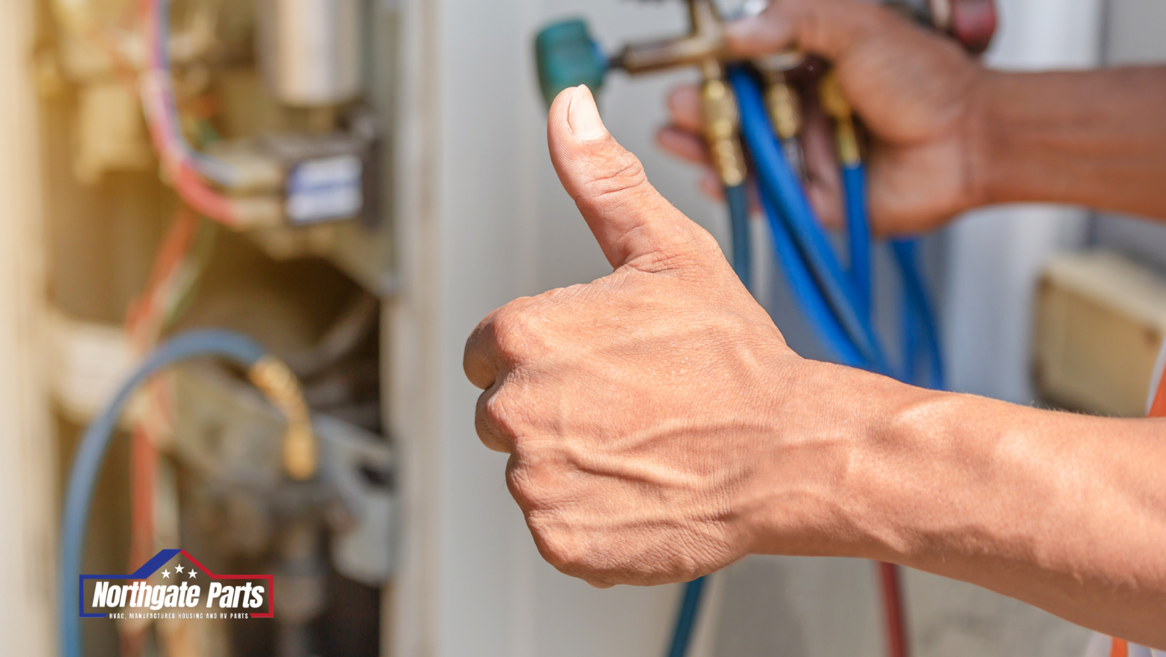 Close-up of a plumber’s hand giving a thumbs-up beside blue hoses and plumbing pipes