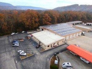 An aerial view of a building with solar panels on the roof.