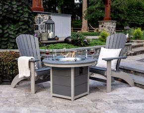 Two chairs are sitting next to a fire pit on a patio. Two chairs are sitting next to a fire pit on a patio.