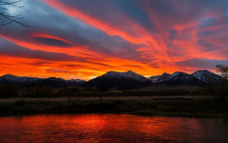 A sunset over a lake with mountains in the background