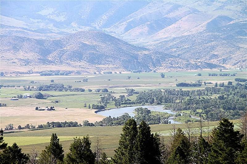 A river runs through a valley with mountains in the background