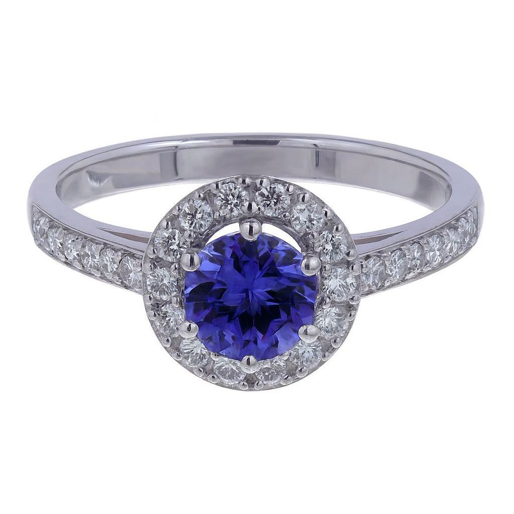 Anello in argento con una gemma blu rotonda e piccole pietre trasparenti che circondano la fascia.