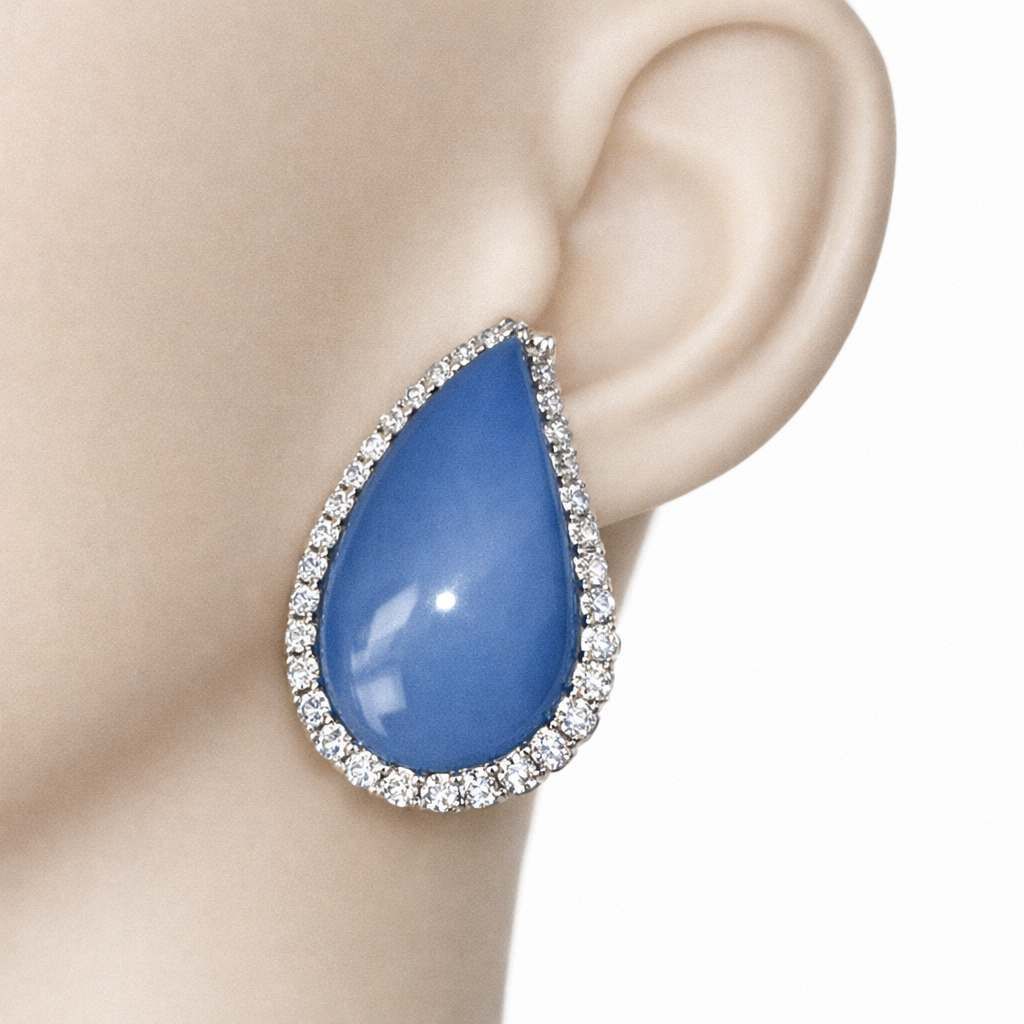Orecchino con gemma a goccia blu e alone di diamanti.
