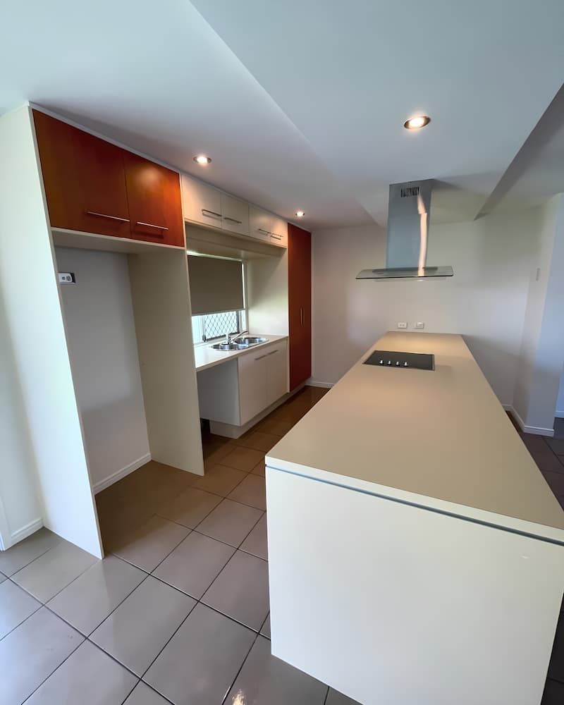 A Kitchen With A Large Island And A Stove Top Oven — Glittering Cleaning Service In Townsville, QLD