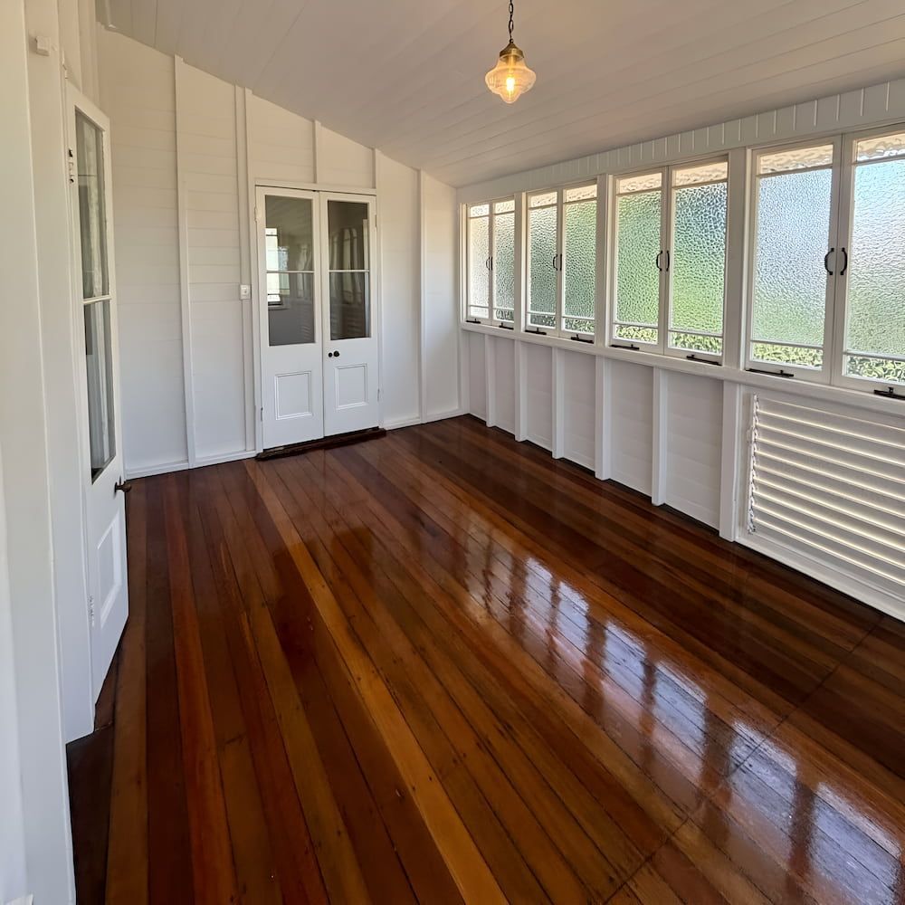 A Room With Hardwood Floors And Lots Of Windows — Glittering Cleaning Service In Townsville, QLD