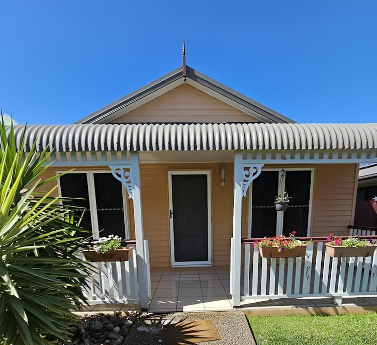 A Small House With A Porch And A Blue Roof — Glittering Cleaning Service In Townsville, QLD
