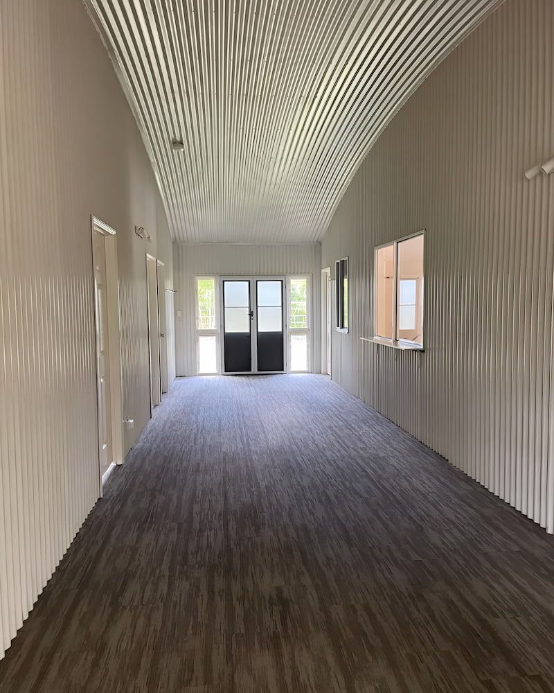 An Empty Hallway With A Wooden Floor And White Walls — Glittering Cleaning Service In Townsville, QLD