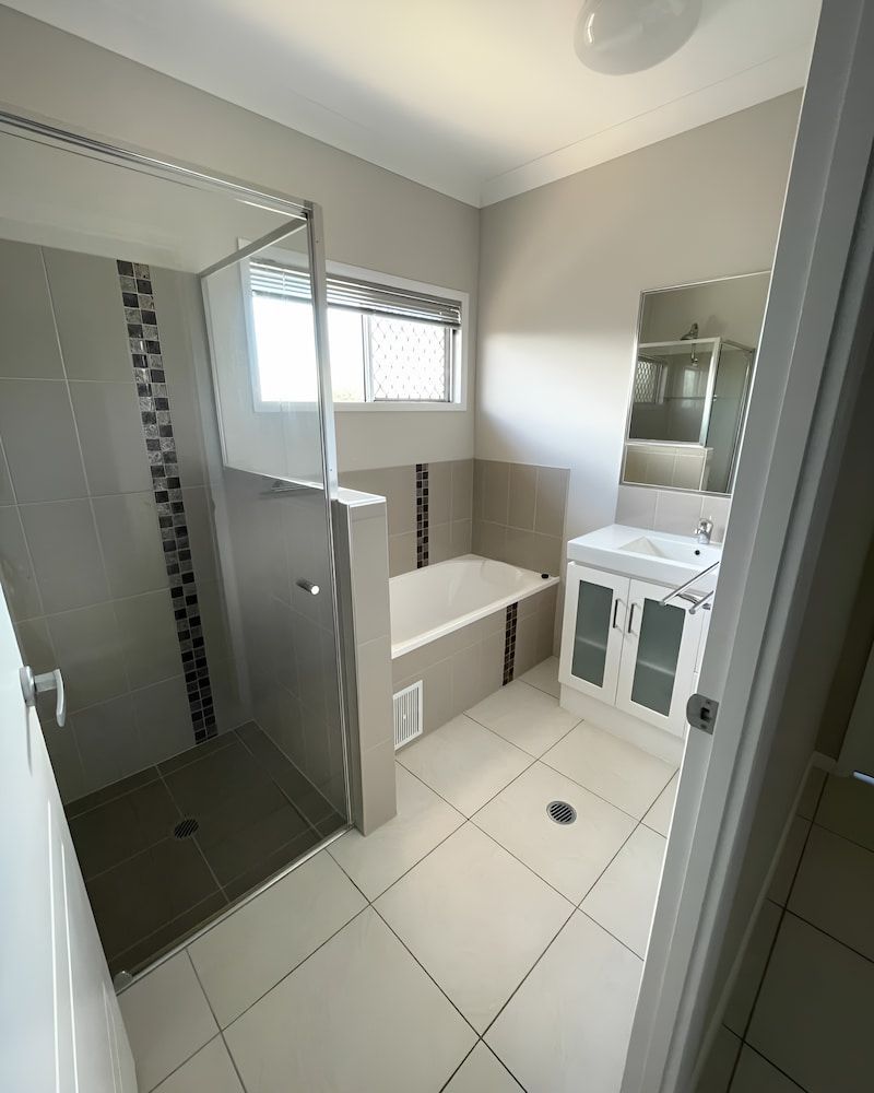A Bathroom With A Bathtub, Sink, Shower And Mirror — Glittering Cleaning Service In Townsville, QLD