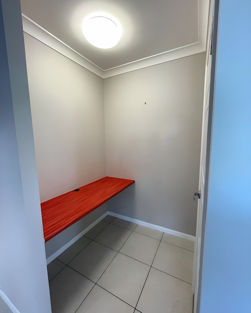 A Small Room With A Red Desk And A Light On The Ceiling — Glittering Cleaning Service In Townsville, QLD