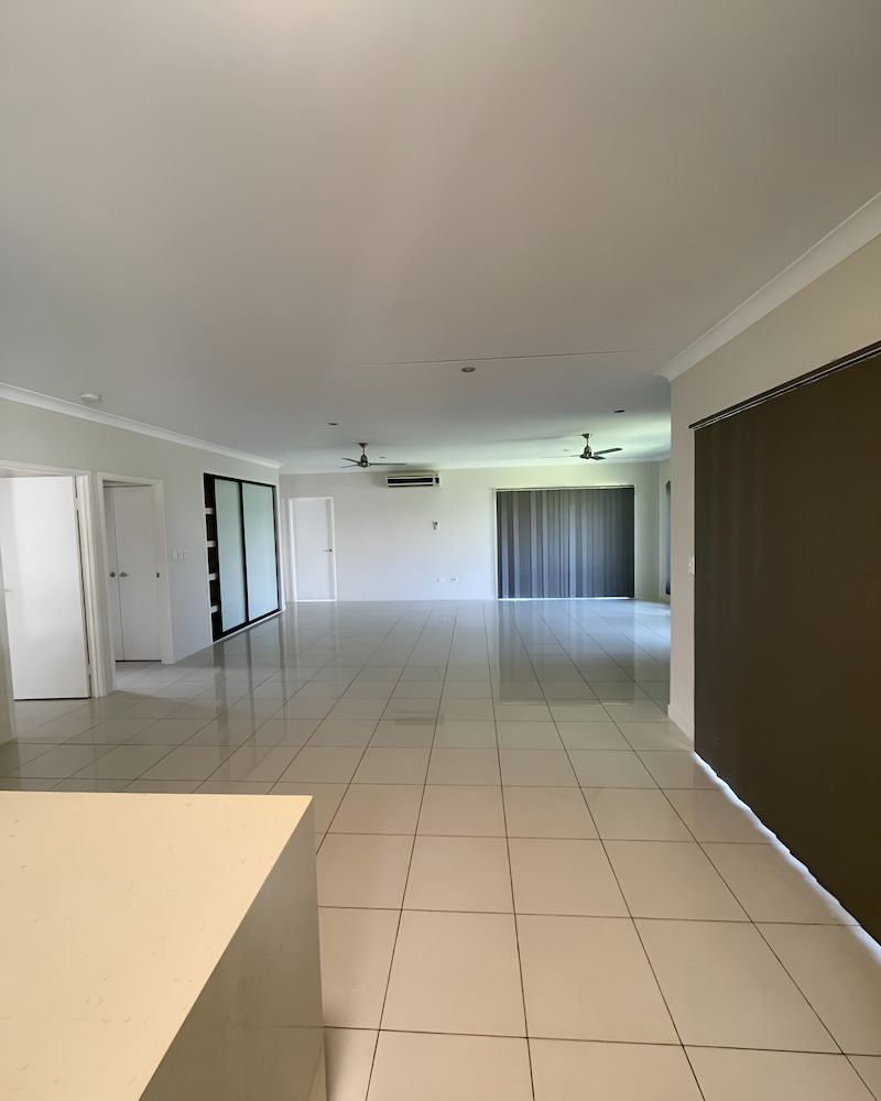 A Large Empty Room With White Tiles And Brown Blinds — Glittering Cleaning Service In Townsville, QLD