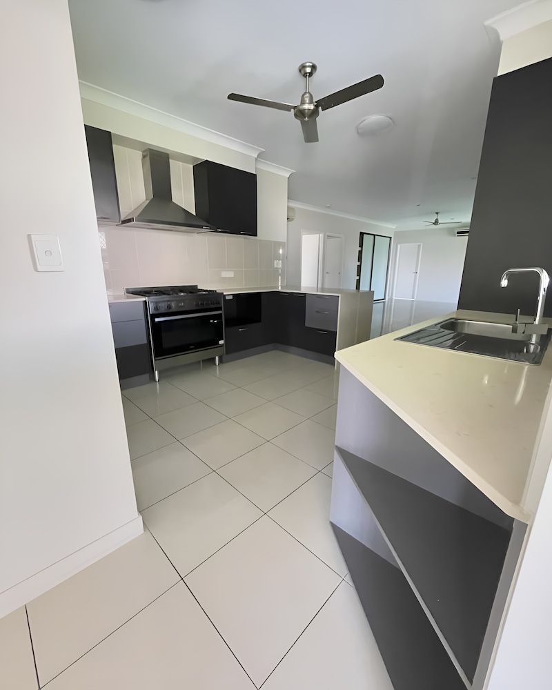 A Kitchen With A Sink , Stove And Ceiling Fan — Glittering Cleaning Service In Townsville, QLD