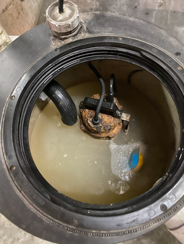 Open sump pit with murky water, submerged pump, and hoses inside a round access hatch — PUMPtek in Grovedale, VIC