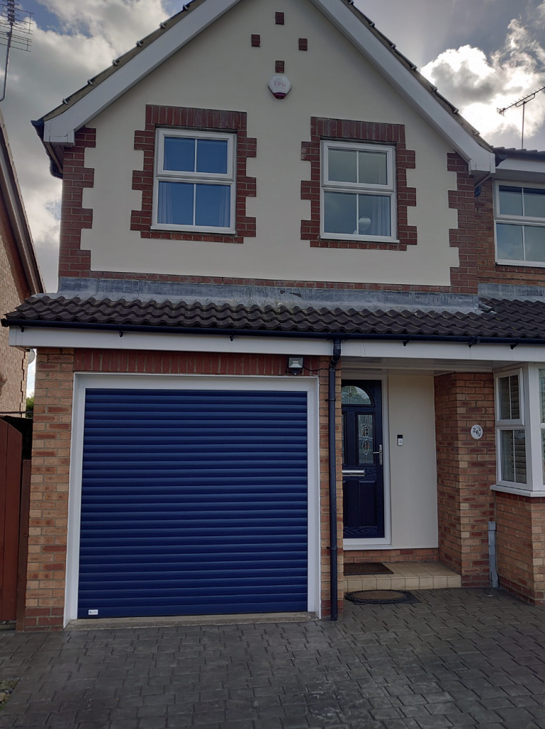 A two-story semi-detached home with cream render, brick detailing, a blue garage door, and a matching blue front door.