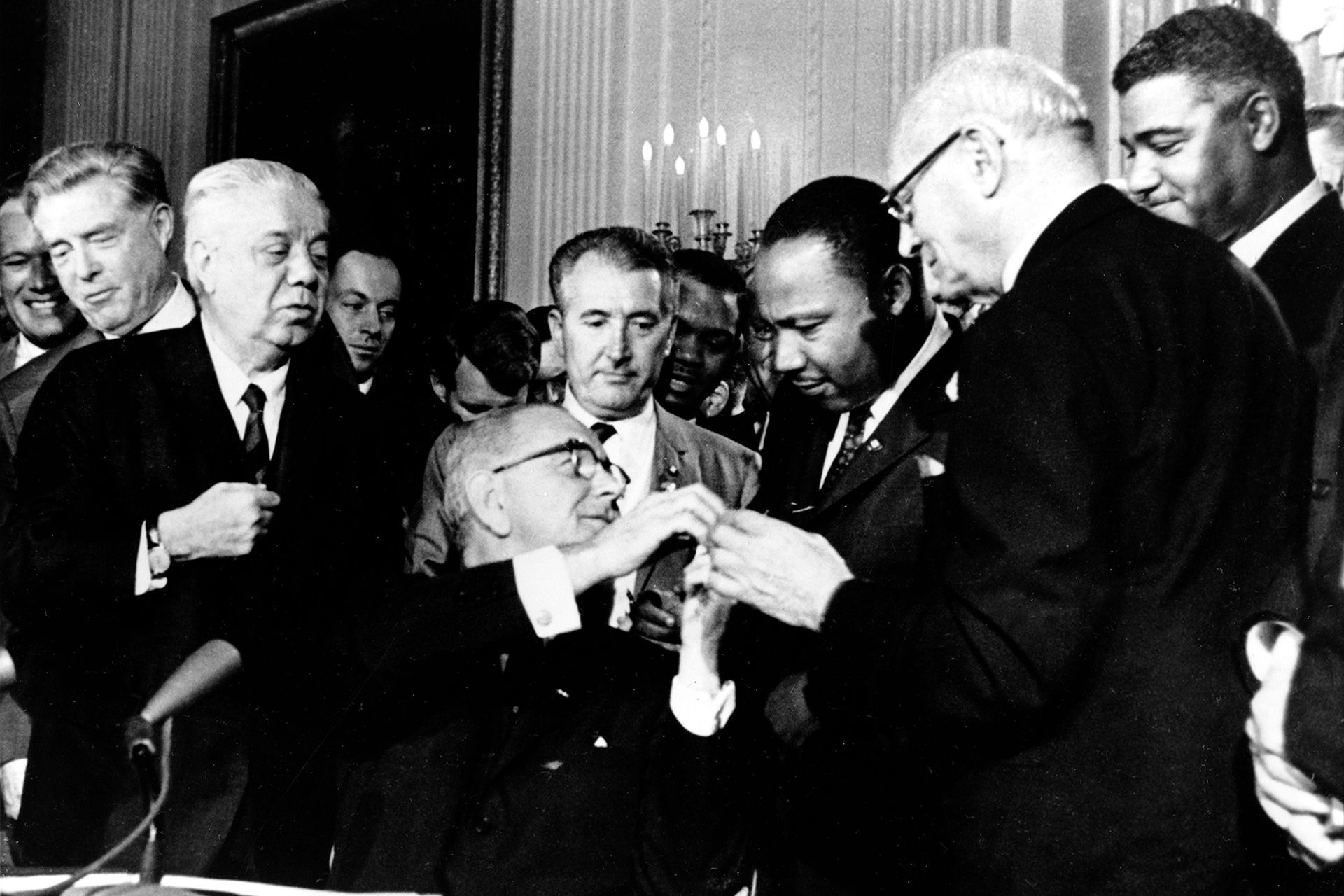 On July 2, 1964, President Lyndon B. Johnson reached to shake hands with Dr. Martin Luther King Jr.