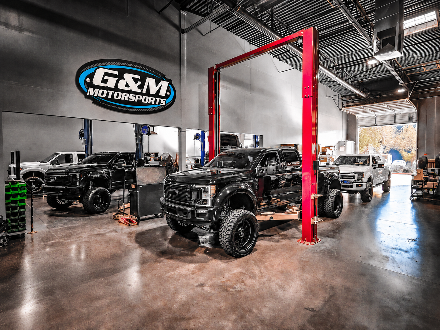 Lifted White Pickup Truck Parked By Shop Building | G & M Motorsports