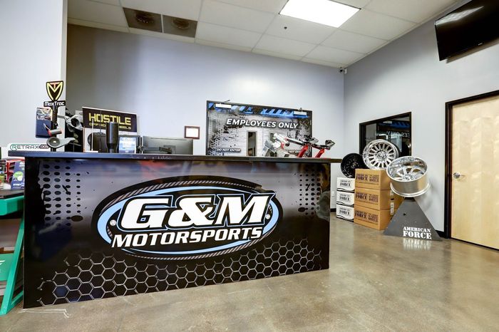 Trucks On Hydraulic Lifts Inside Service Bay | G & M Motorsports
