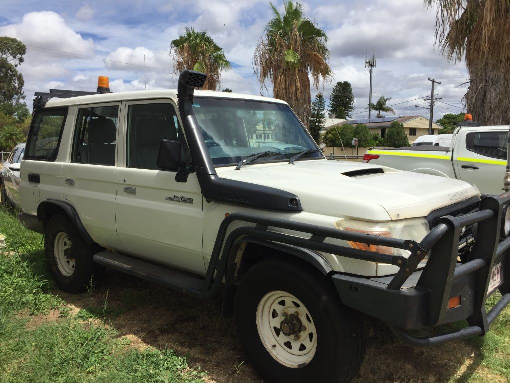 A White SUV With a Snorkel is Parked in a Grassy Area — Locqal Car Truck Trailer Rentals in Emerald, QLD