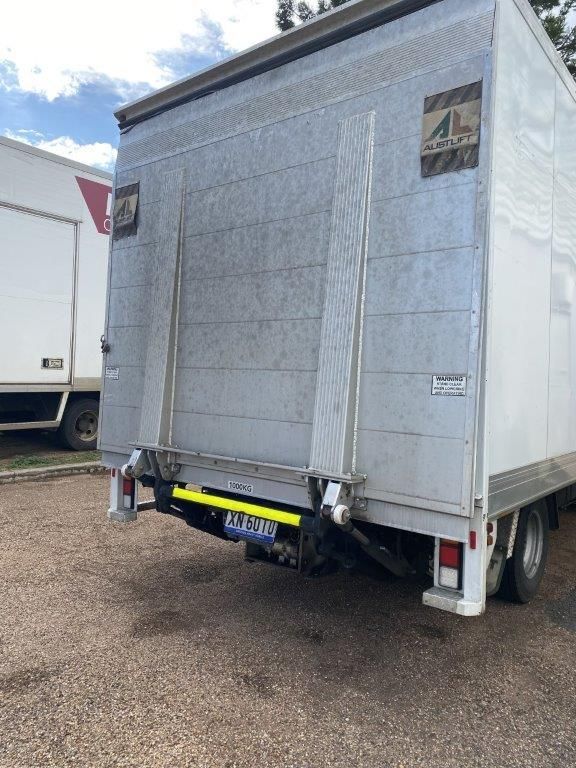 Rear view of a white Locqal hire truck with hydraulic tailgate lift in Emerald