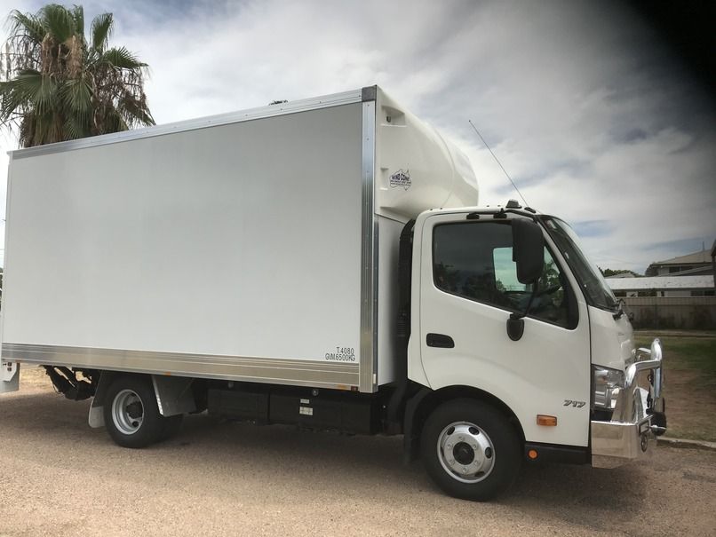Two White Delivery Trucks Parked At The Warehouse — Locqal Car Truck Trailer Rentals in Emerald, QLD
