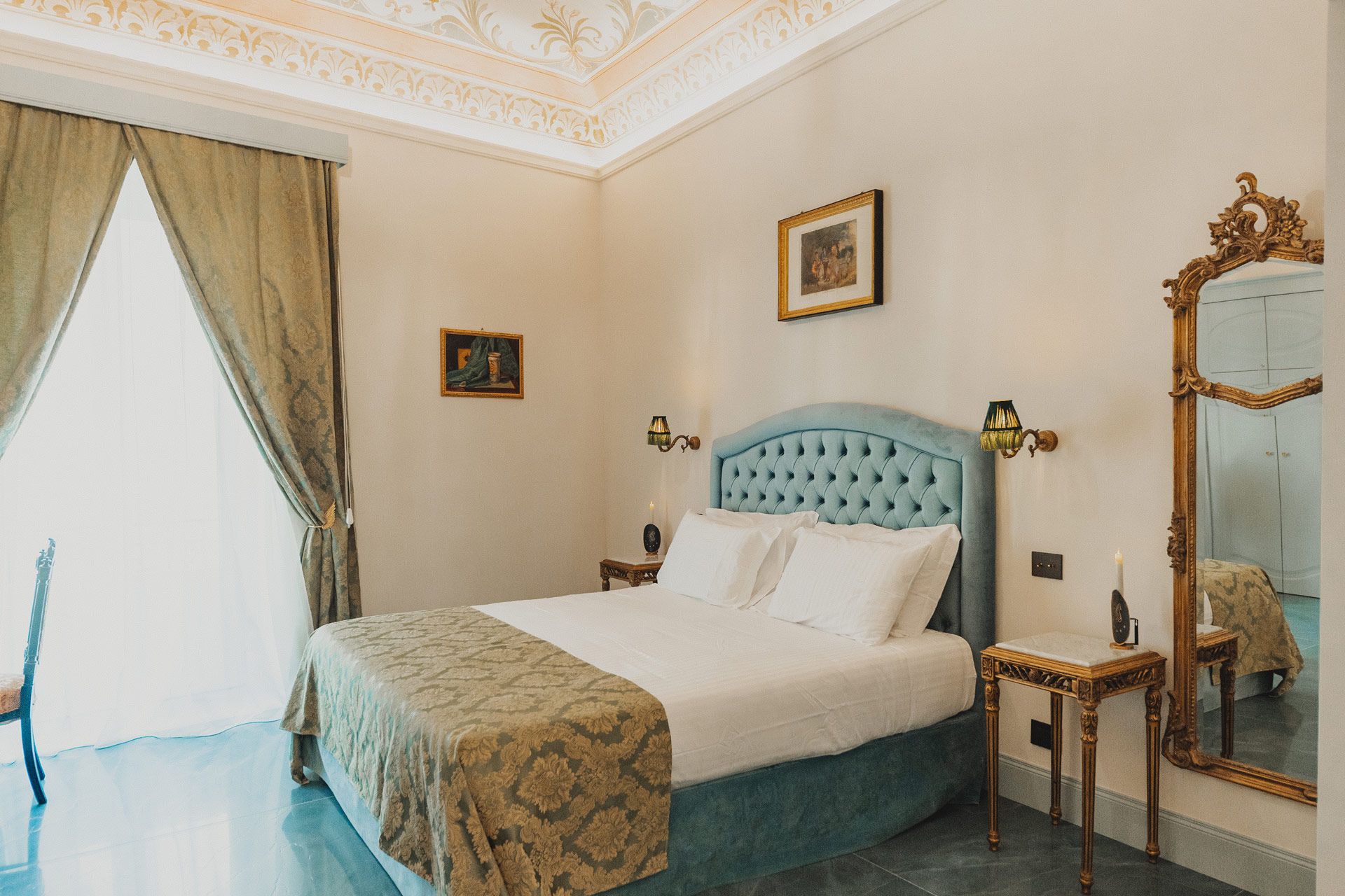Elegante camera da letto con letto trapuntato turchese, specchio decorato e pareti color crema tenue.
