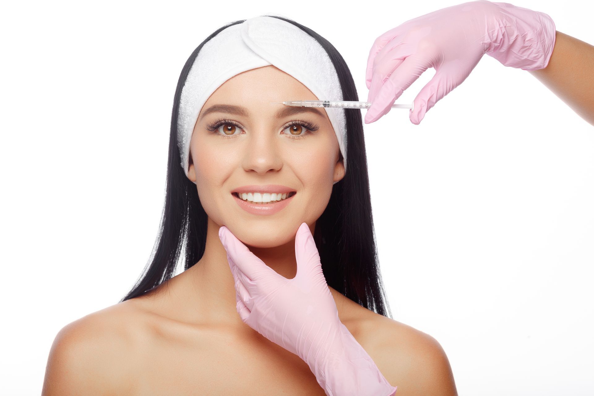 A woman is getting a botox injection in her forehead.