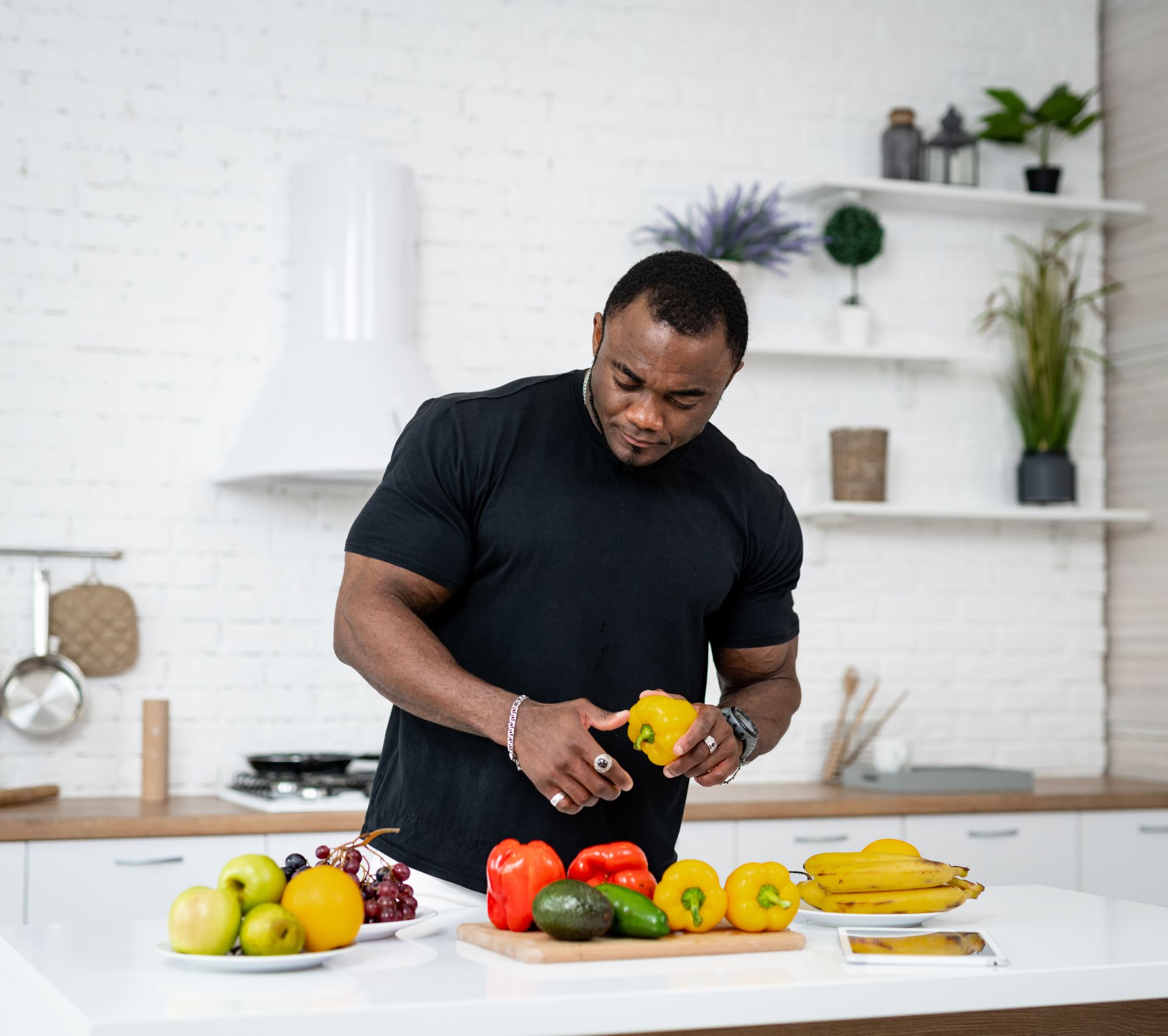 A man is cutting peppers on a cutting board in a kitchen.