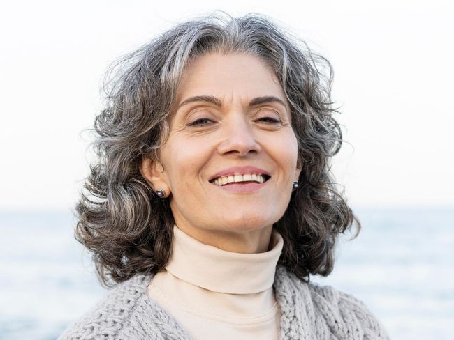 A close up of a woman 's face with her hand on her chin.