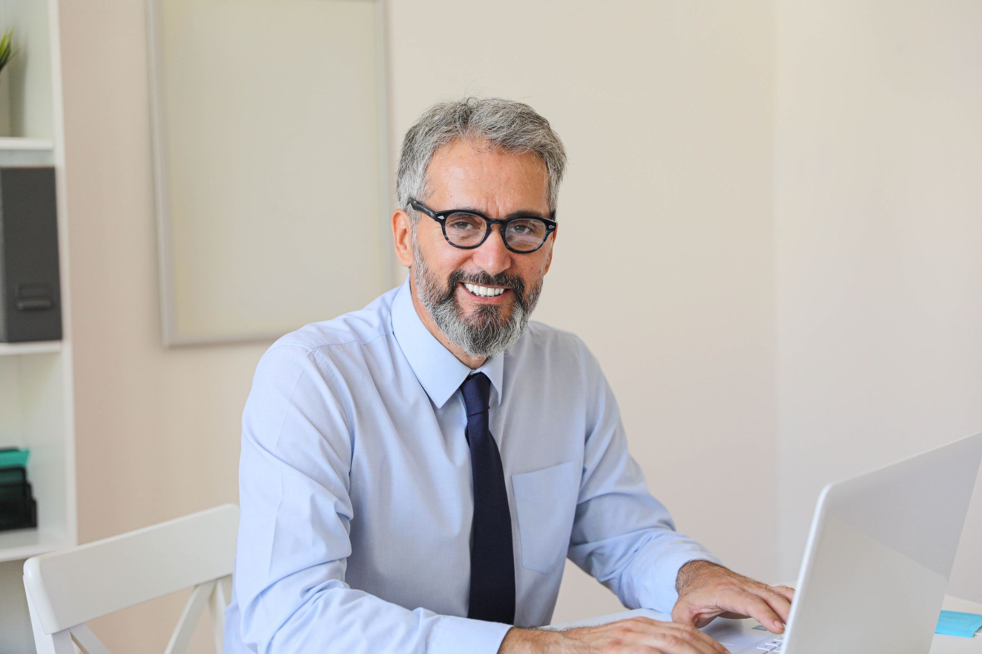 A man is sitting at a desk using a laptop computer.