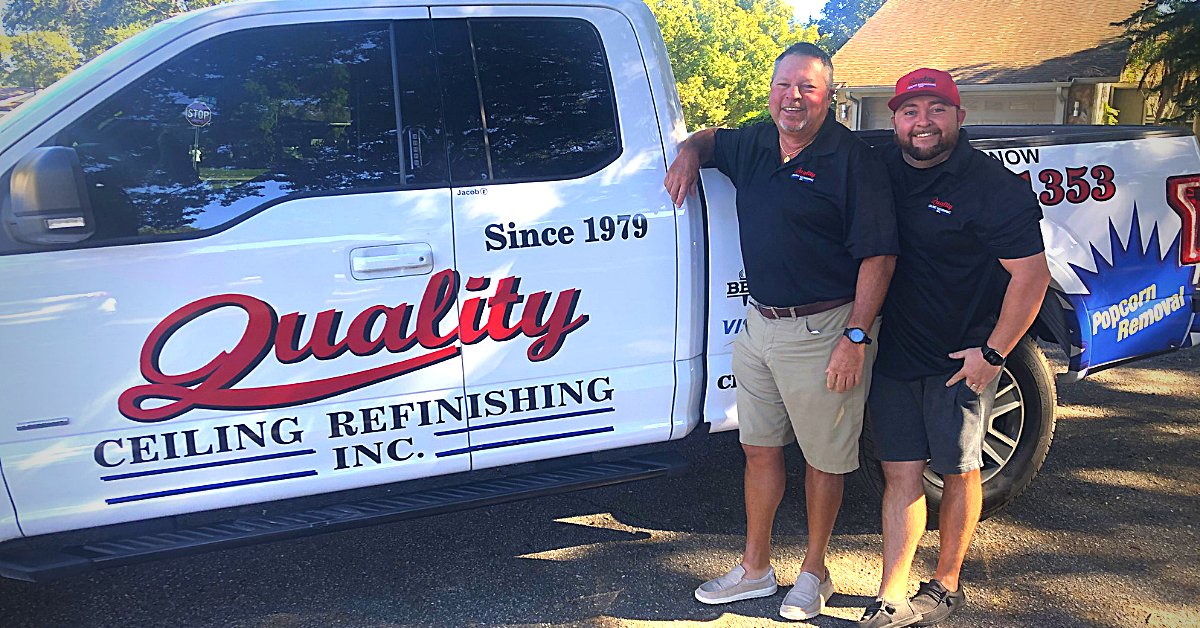 Two men stand by a white truck with