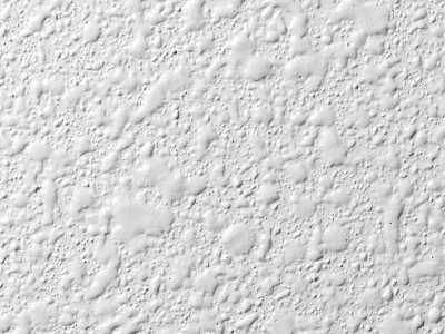 White textured wall with a bumpy, uneven surface.