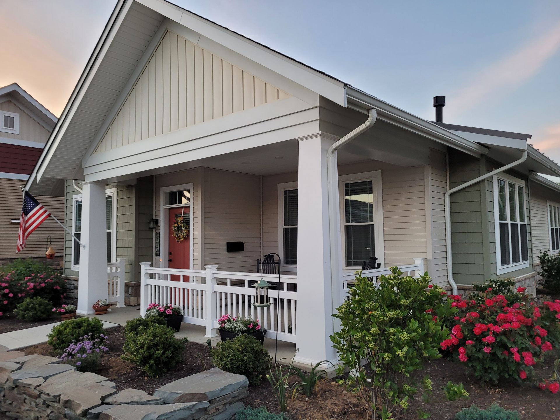 Residential cottage exterior with white vinyl railings installed by Millcreek Fence