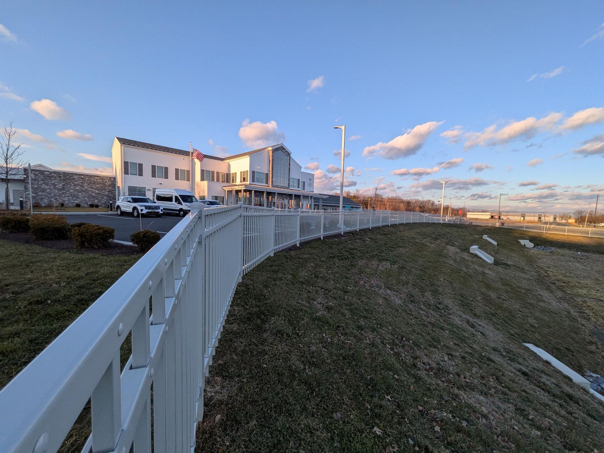 Commercial safety fence protecting retention pond at school campus