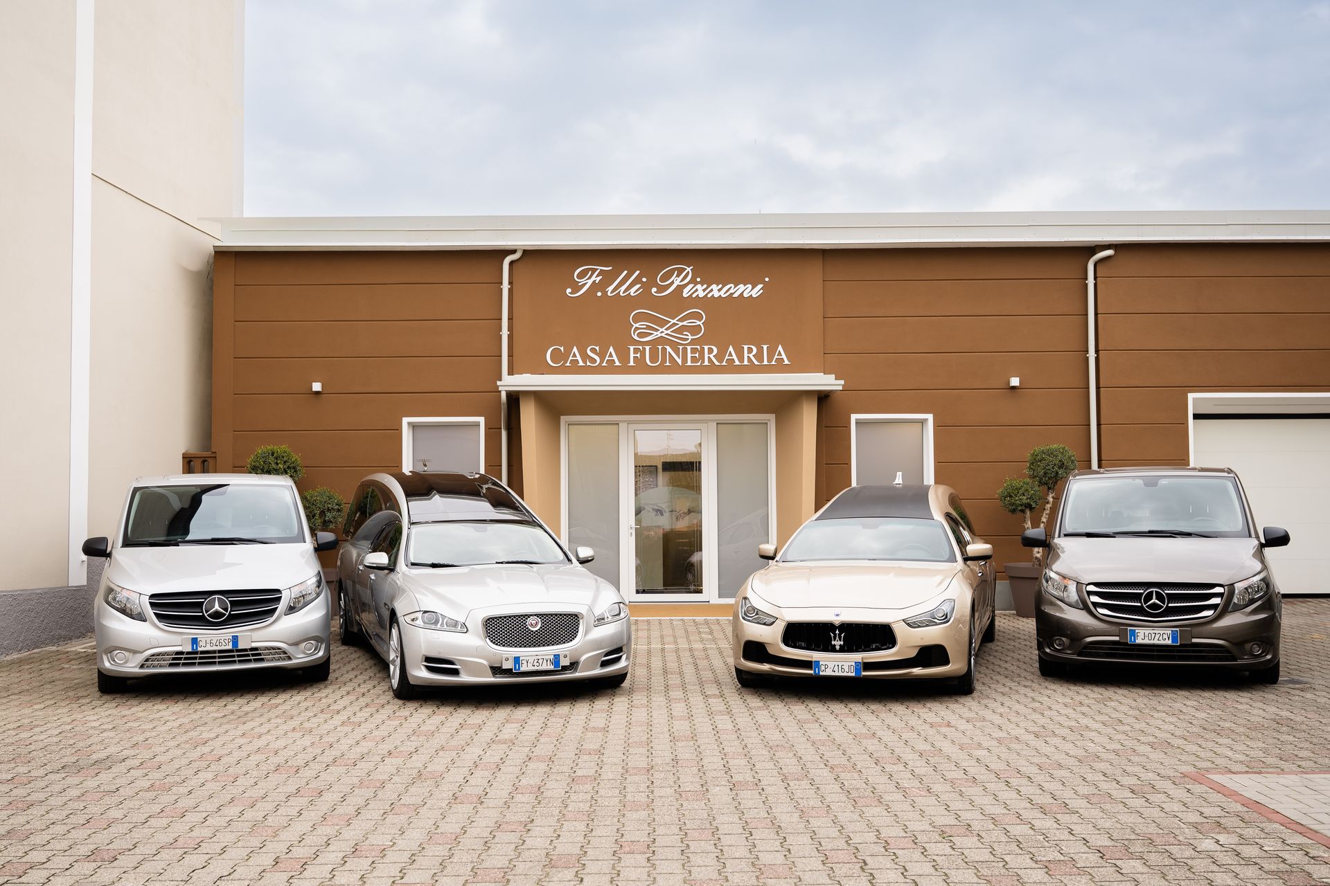Quattro auto funebri parcheggiate davanti all'edificio della Casa Funeraria.