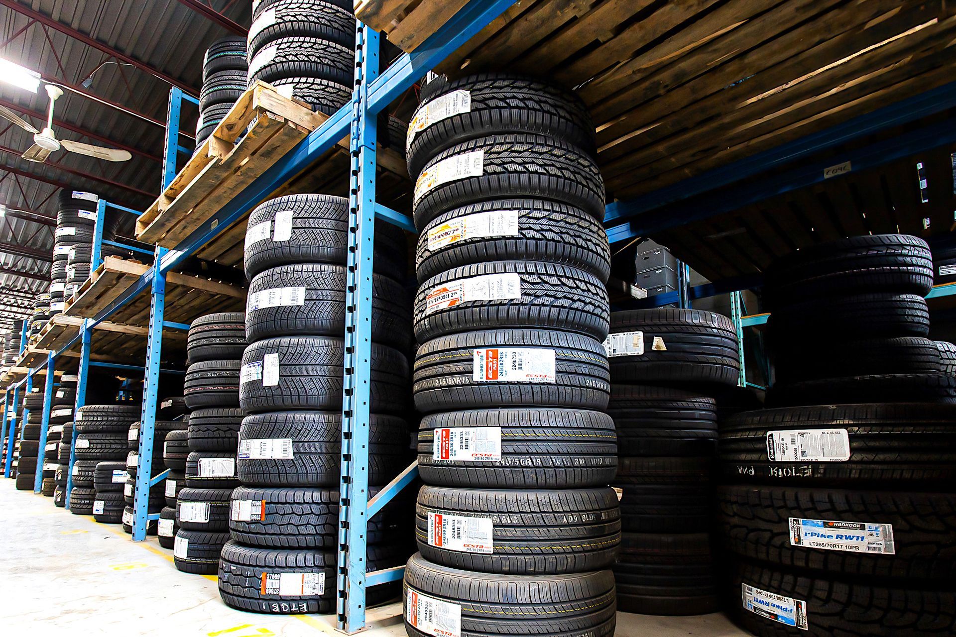 Tires stacked on warehouse shelves. Several stacks of new tires, close-up view.
