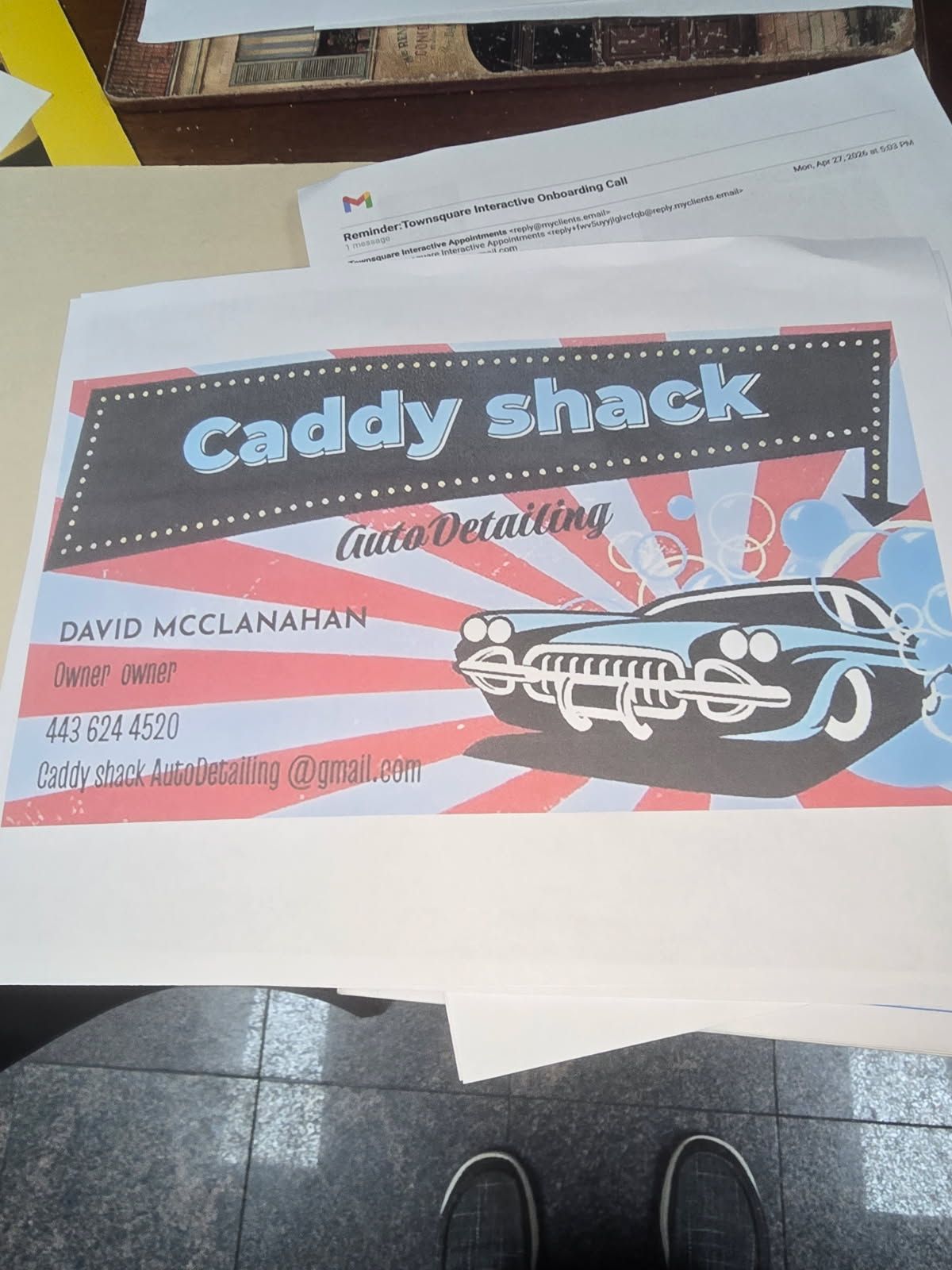 Caddy Shack concert flyer on a table, with black, red, and white retro car graphics.
