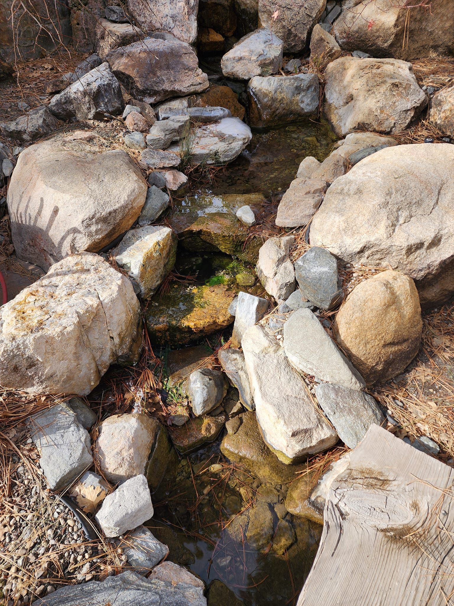A stream of water running through a pile of rocks.