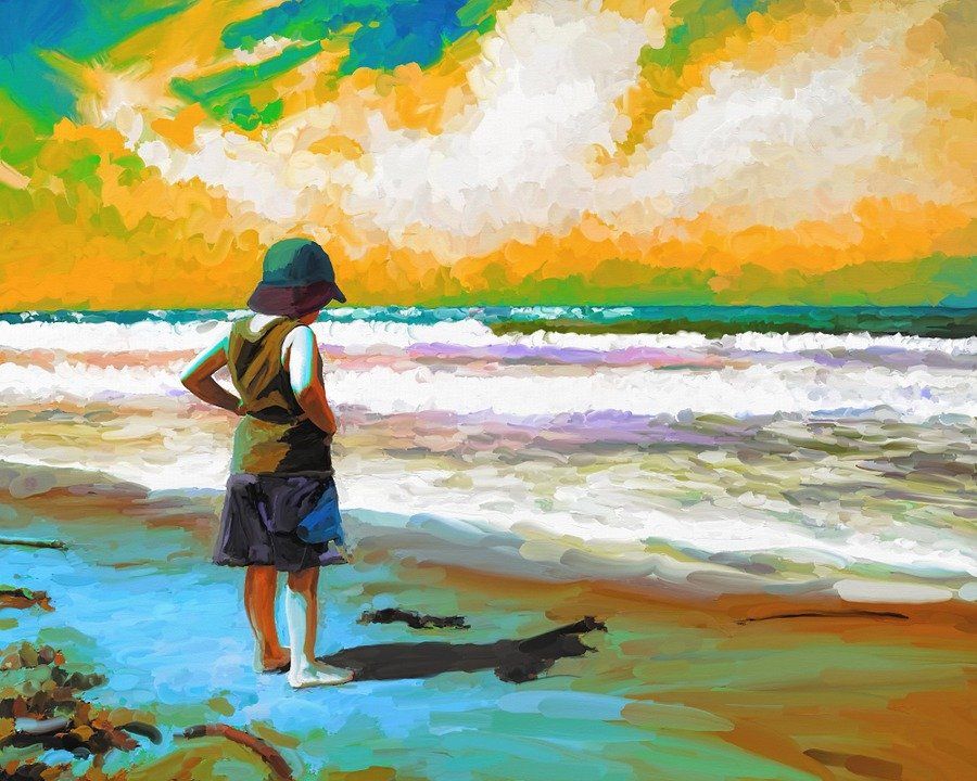 Person standing on a beach looking at waves under a bright, colorful sky