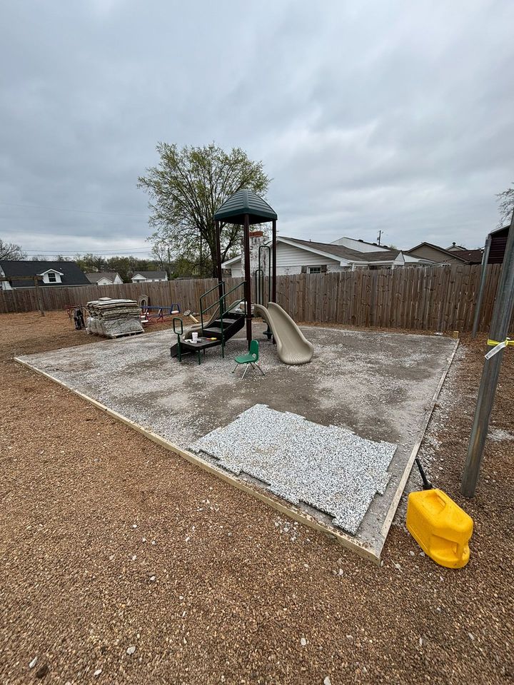 Backyard playground with slide, swing, and wood chip ground under a cloudy sky