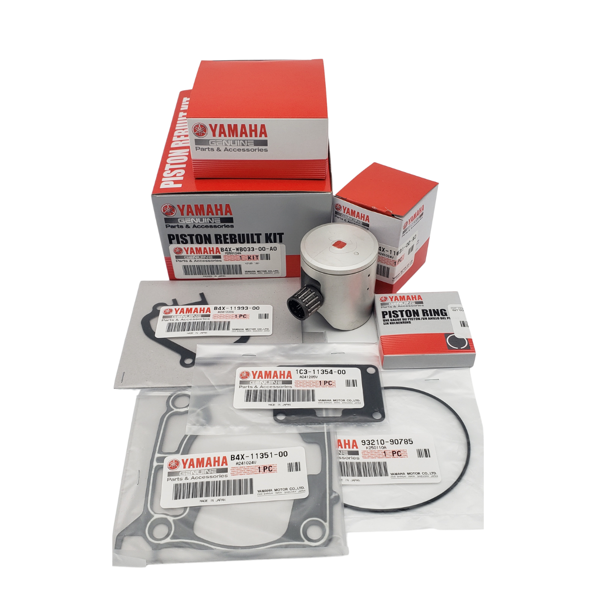 Yamaha piston rebuild kit parts: piston, rings, gaskets, in boxes and packaging.