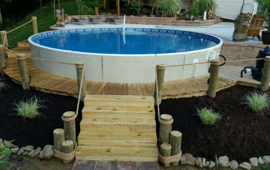 A swimming pool with a wooden deck and stairs leading to it.