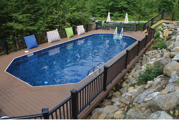 A man is holding a hose surrounded by swimming pool supplies.