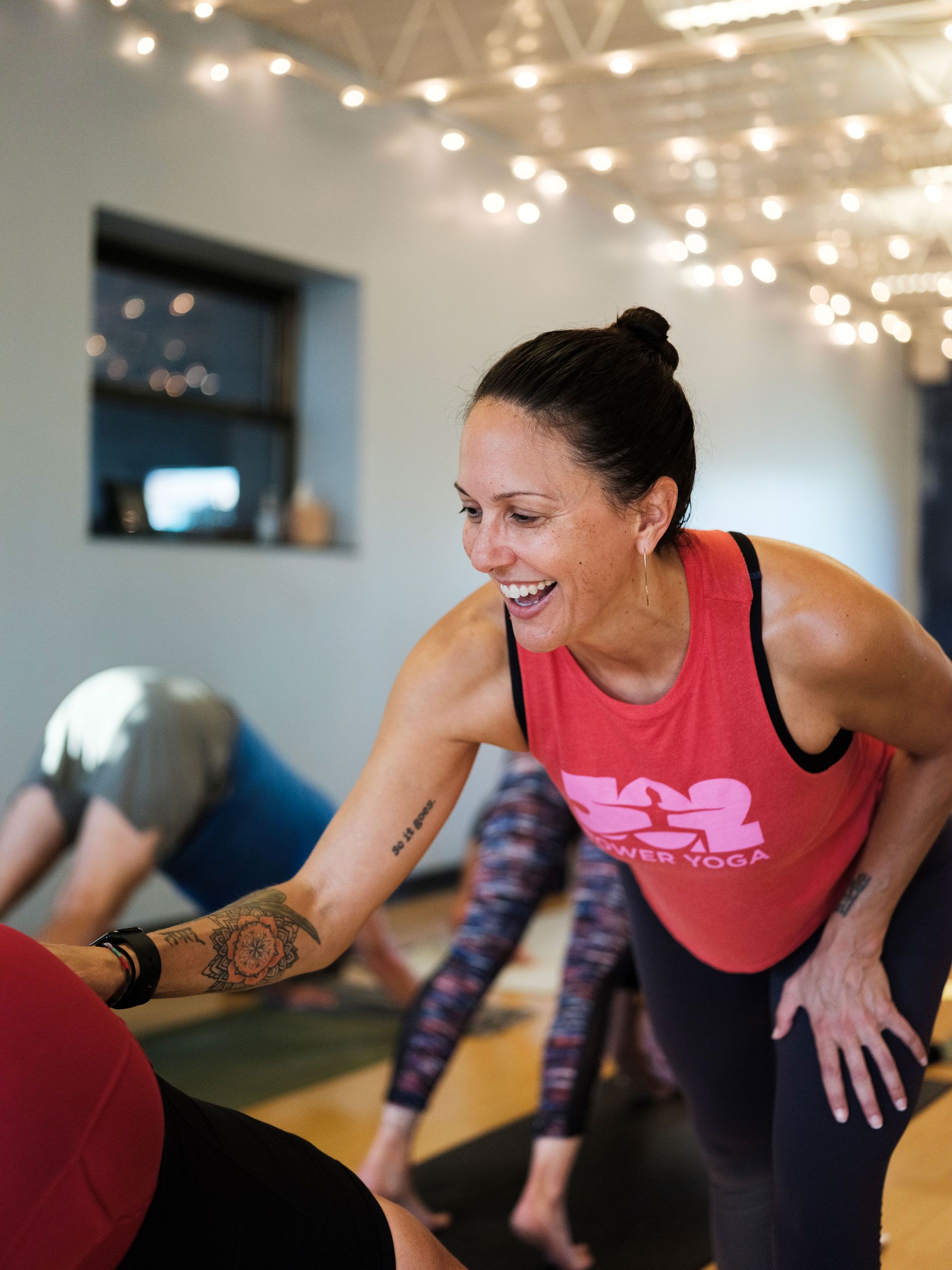 Yoga teacher Cat Scott assisting a student at 502 Power Yoga