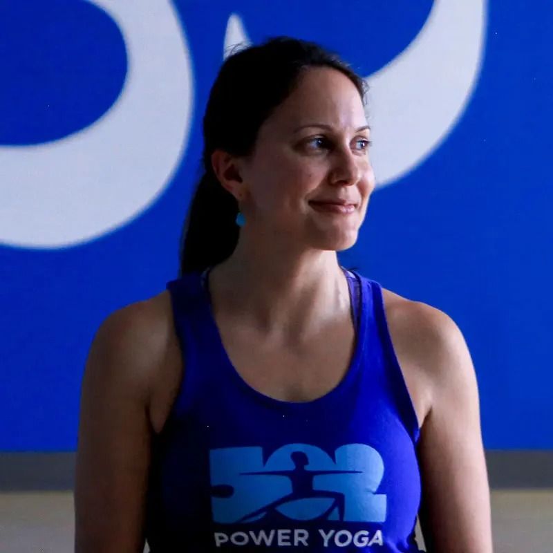 A person smiles while wearing a blue tank top with 