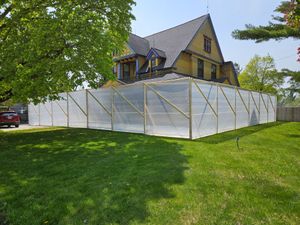 A house is being demolished and a fence is surrounding it.