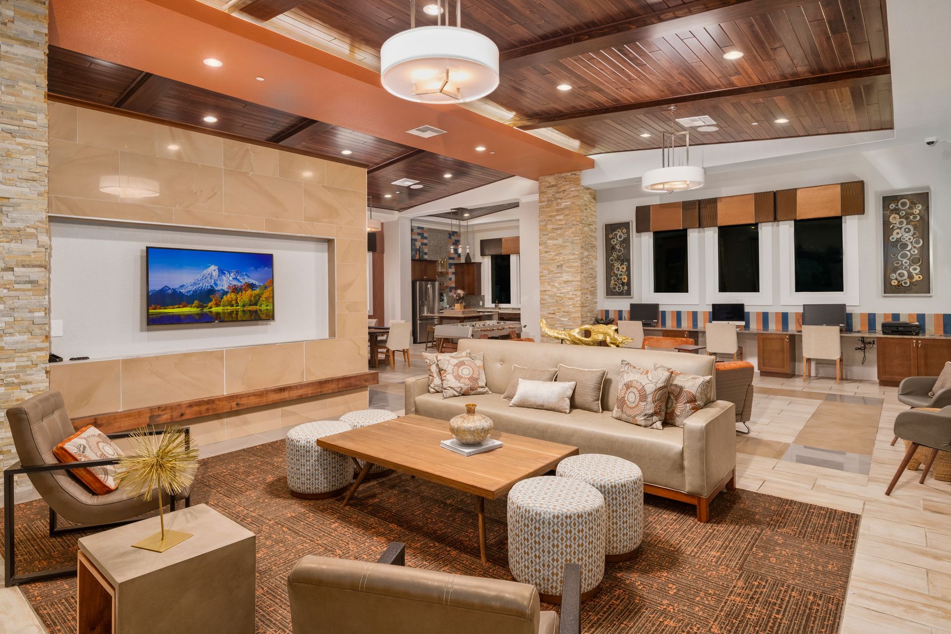 Luxurious living room with sectional sofa, coffee table, fireplace, and wall-mounted TV under wood ceiling