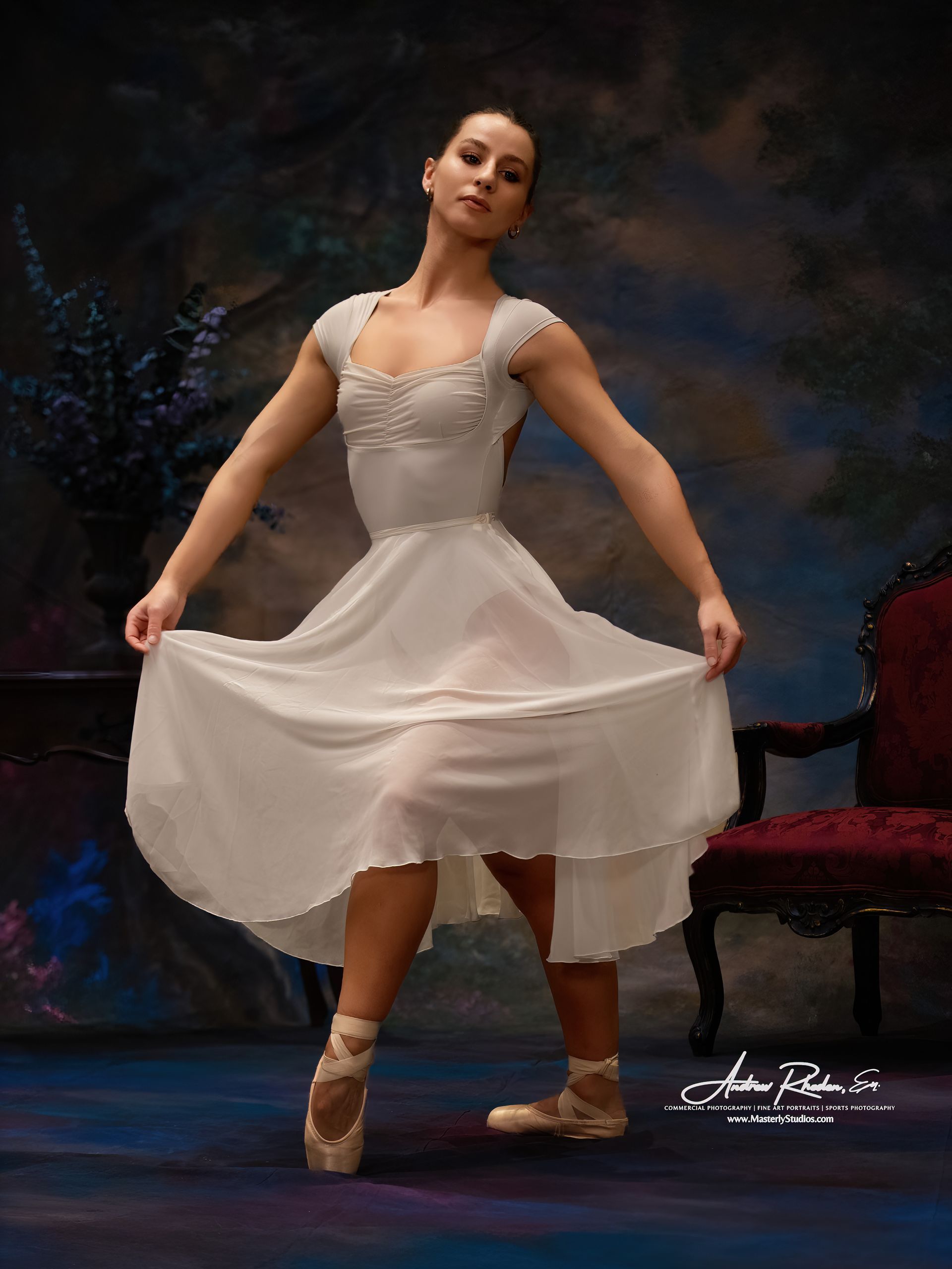 Ballet dancer in a white dress and pink pointe shoes poses mid-performance on a dark stage.