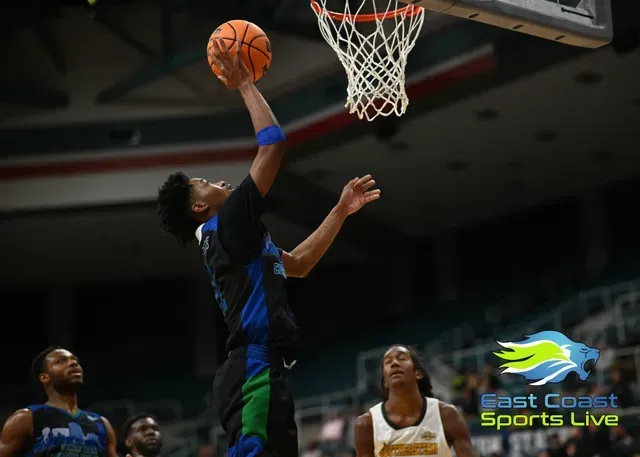 Basketball player in black drives for a layup under the hoop, with defenders nearby and Sports Live logo.