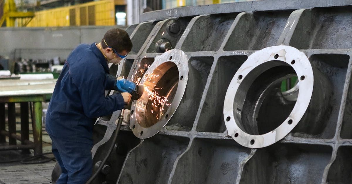 A man is working on a piece of metal in a factory.
