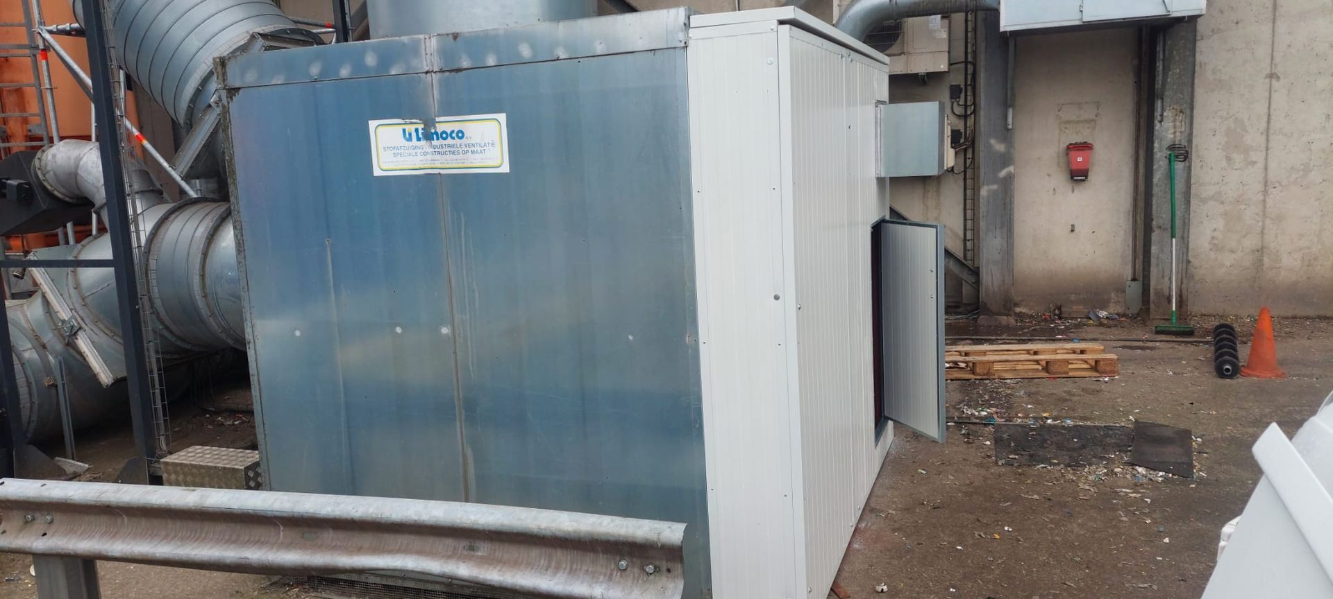 Grote industriële ventilatie-installatie naast een gebouw.
