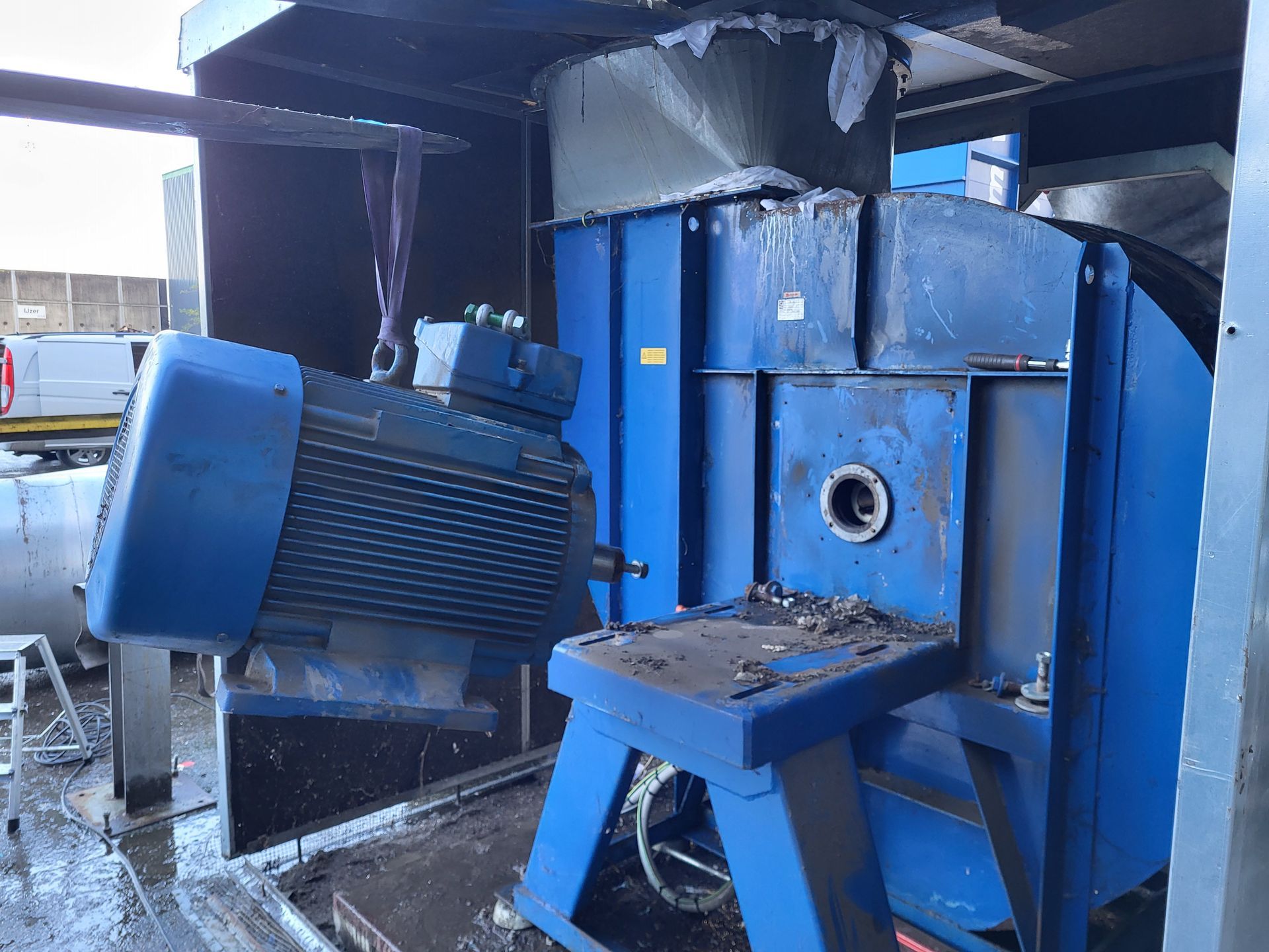 Blauwe industriële shredder met aangebouwde motor.
